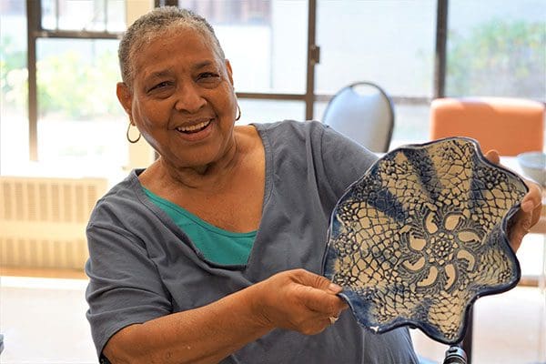 Resident of Kline Galland Home in Seattle showing off the pottery she created