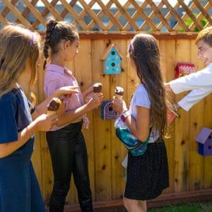 Children looking at bird houses with woman