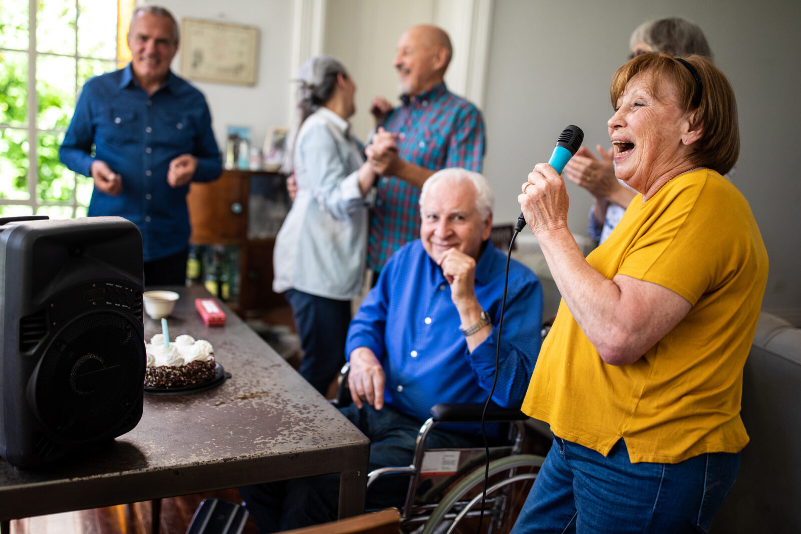 Group of Senior people having fun at Karaoke party, celebrating birthday in shared community space